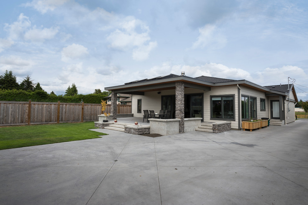 Großer, Überdachter Moderner Patio hinter dem Haus mit Kübelpflanzen und Betonplatten in Vancouver