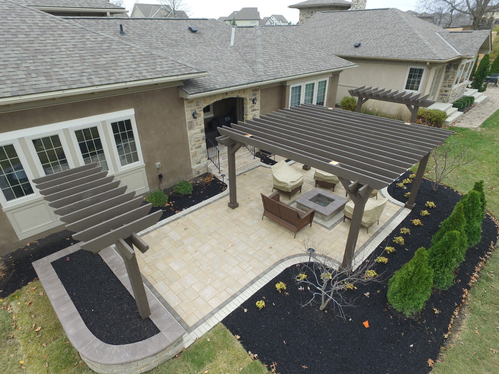 Immagine di un patio o portico contemporaneo di medie dimensioni e dietro casa con un focolare, pavimentazioni in cemento e una pergola