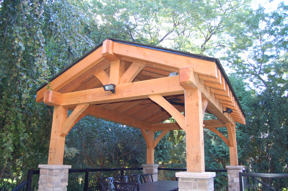 Example of a mid-sized mountain style backyard patio design in Toronto with a roof extension and decking
