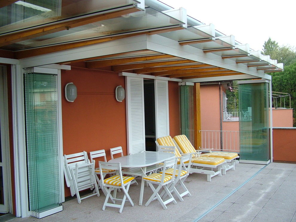 Cette image montre une terrasse design avec une dalle de béton et un auvent.