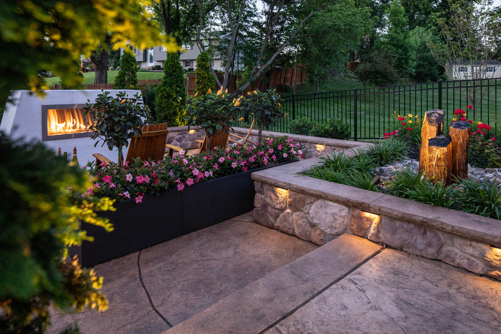 Foto di un patio o portico minimal di medie dimensioni e dietro casa con un focolare e cemento stampato