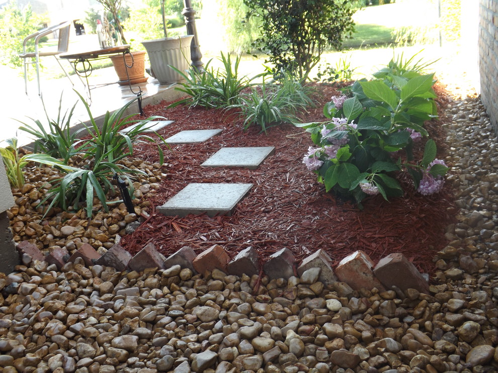 Design ideas for a mid-sized traditional backyard gravel landscaping in New Orleans.