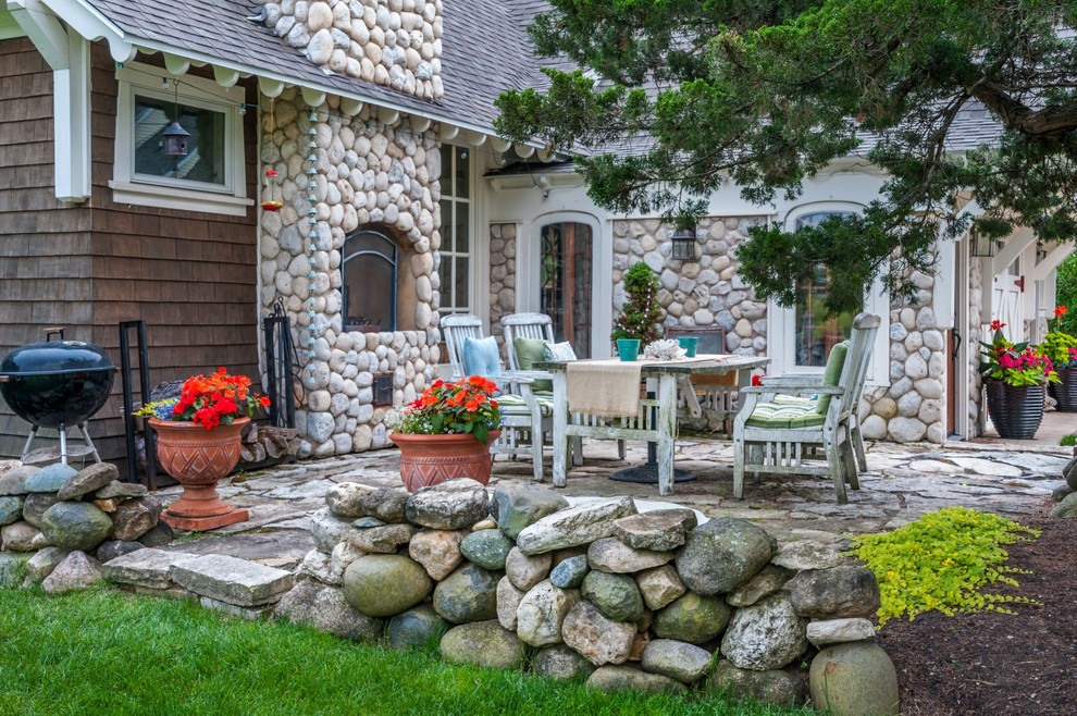 Idee per un patio o portico stile marinaro di medie dimensioni e davanti casa con un focolare e pavimentazioni in pietra naturale