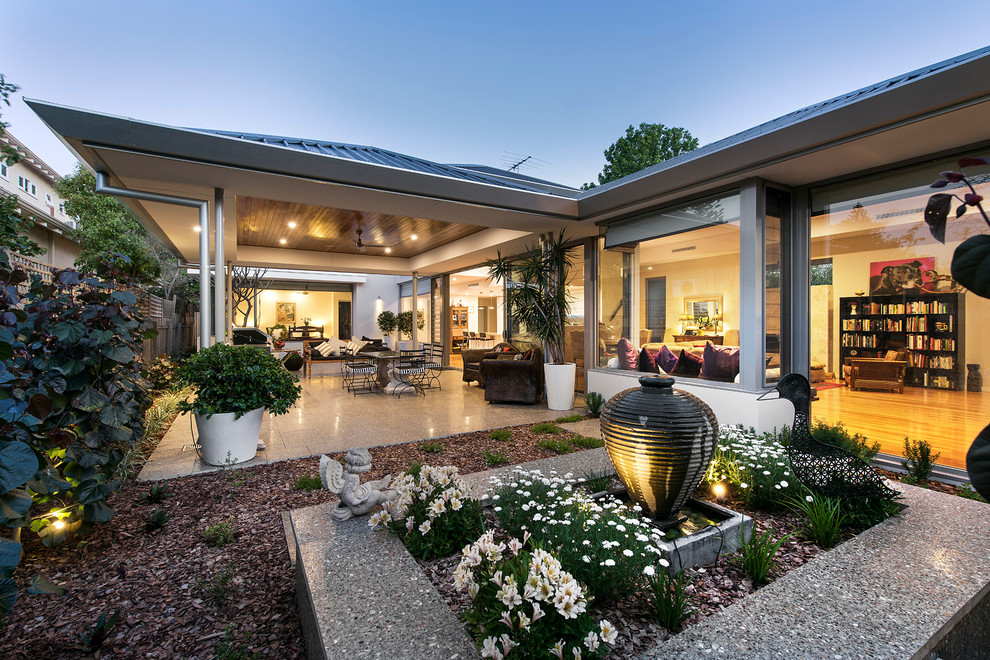 Esempio di un piccolo patio o portico minimal dietro casa con fontane, pavimentazioni in pietra naturale e un gazebo o capanno