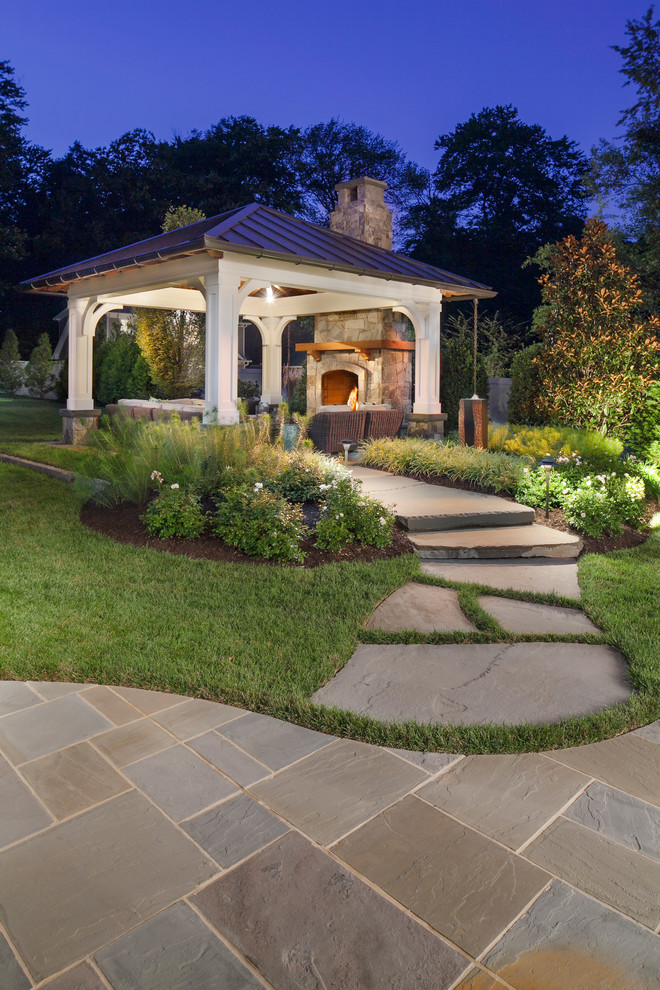 Foto di un patio o portico minimal di medie dimensioni e dietro casa con un focolare, pavimentazioni in pietra naturale e una pergola