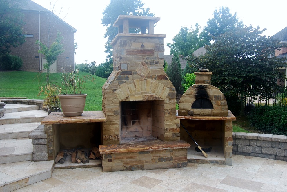 Idée de décoration pour une grande terrasse arrière tradition avec une cuisine d'été, des pavés en pierre naturelle et aucune couverture.