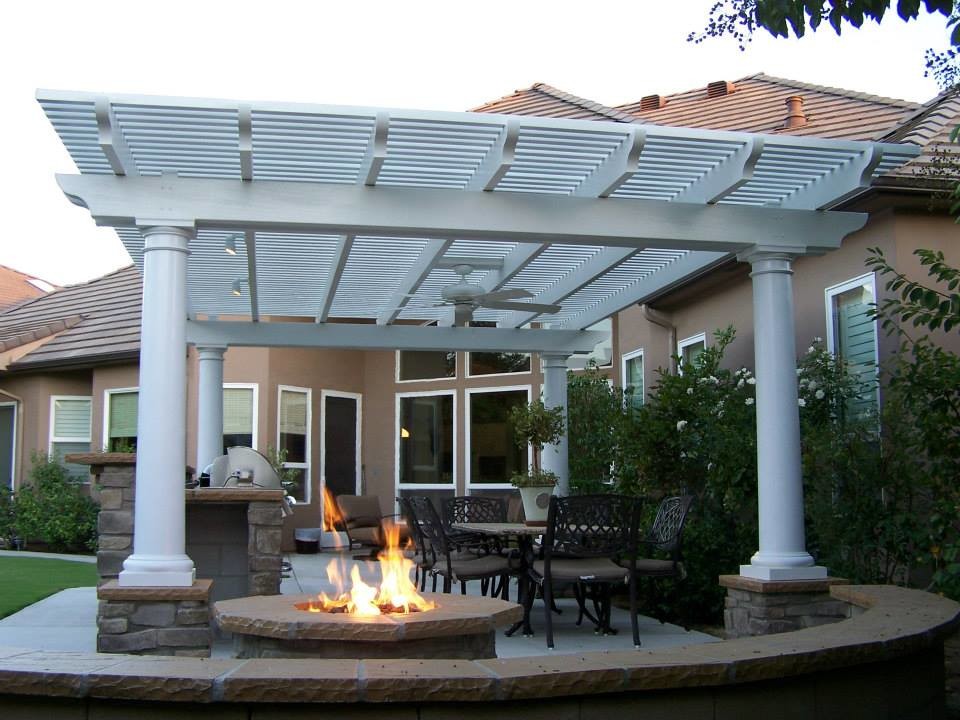Diseño de patio mediterráneo de tamaño medio en patio trasero con cocina exterior, losas de hormigón y pérgola