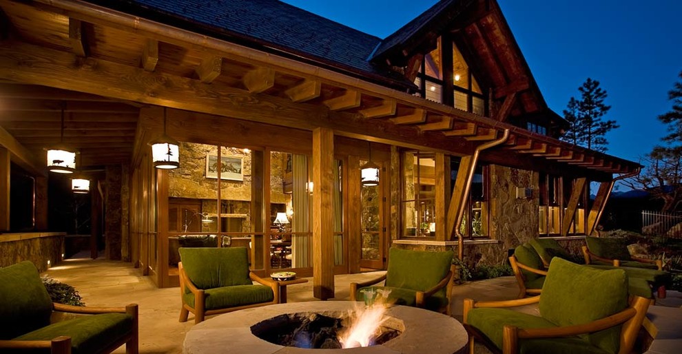 Cette photo montre une terrasse moderne avec un foyer extérieur et des pavés en pierre naturelle.