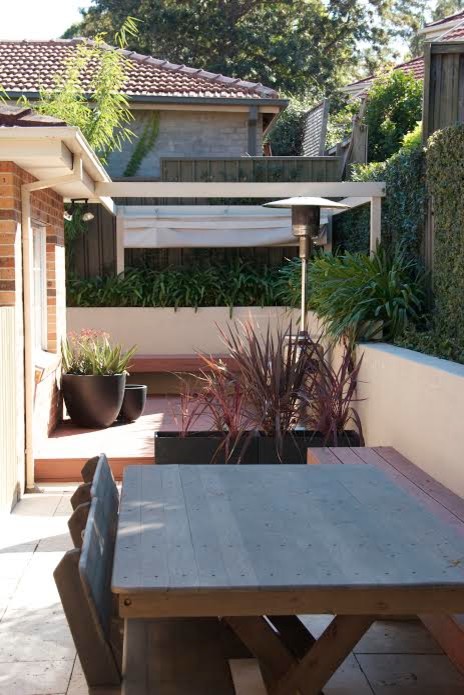 Стильный дизайн: двор среднего размера на боковом дворе в стиле модернизм с вертикальным садом, мощением тротуарной плиткой и козырьком - последний тренд