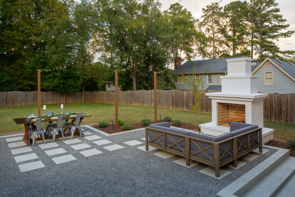 Diseño de patio clásico renovado sin cubierta en patio trasero con chimenea y adoquines de hormigón
