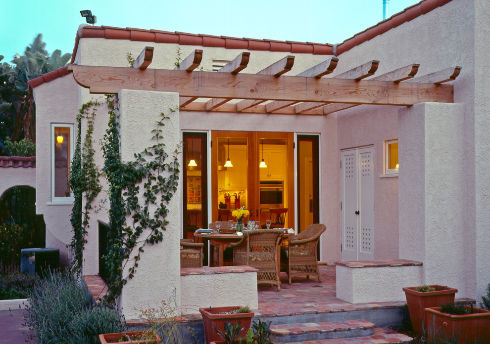 На фото: пергола во дворе частного дома среднего размера на заднем дворе в средиземноморском стиле с покрытием из плитки с