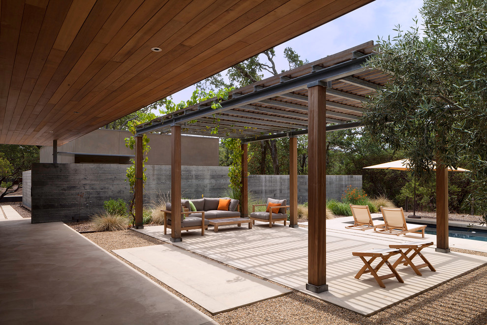 This is an example of a contemporary patio in San Francisco with concrete slabs and a pergola.