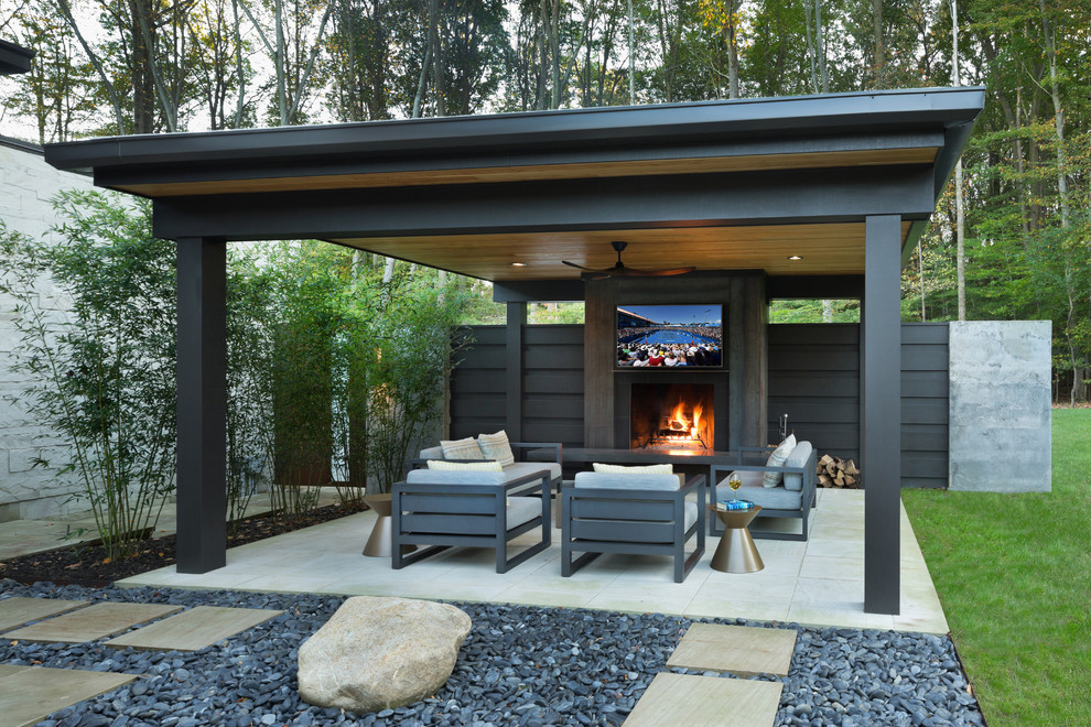 Modelo de patio moderno de tamaño medio en patio trasero con brasero, adoquines de piedra natural y cenador
