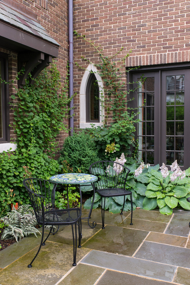 Foto de patio clásico de tamaño medio sin cubierta en patio lateral con adoquines de piedra natural