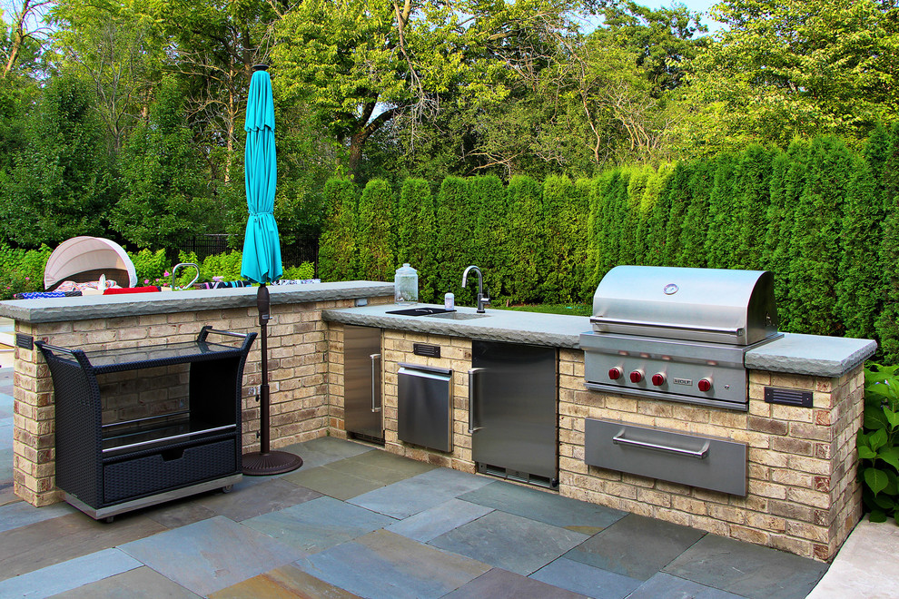 Inspiration for a timeless backyard stone patio kitchen remodel in Chicago