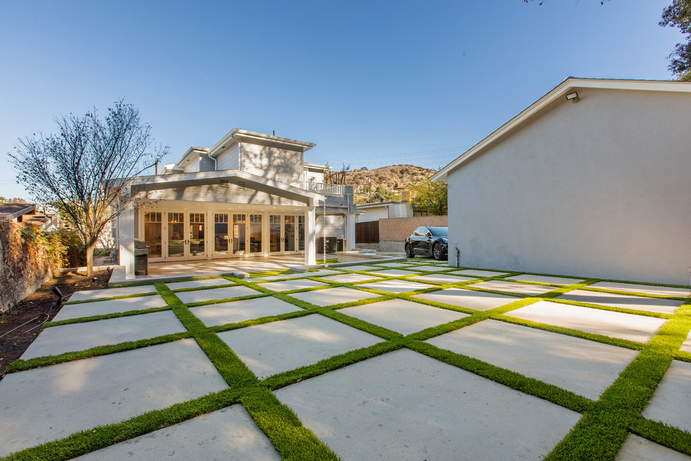 ロサンゼルスにある広いトランジショナルスタイルのおしゃれな裏庭のテラス (タイル敷き、張り出し屋根) の写真