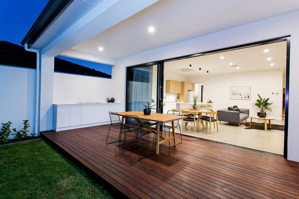 Cette image montre une terrasse en bois arrière design de taille moyenne avec une cuisine d'été et une extension de toiture.