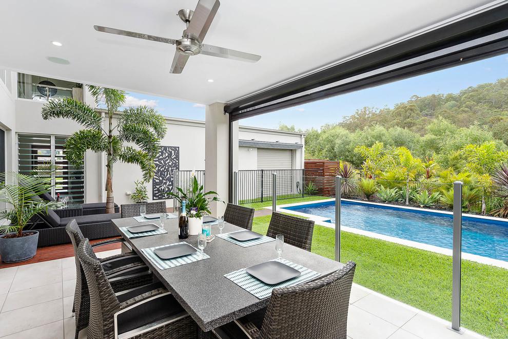 This is an example of a contemporary patio in Gold Coast - Tweed with a roof extension.