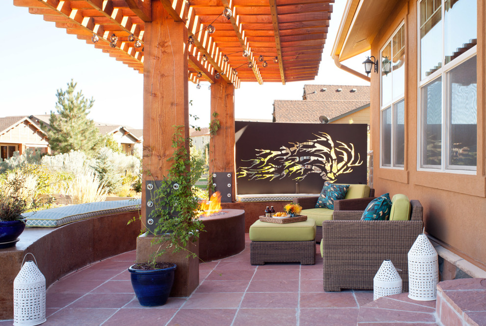 Idée de décoration pour une terrasse arrière vintage avec un foyer extérieur, des pavés en pierre naturelle et une pergola.