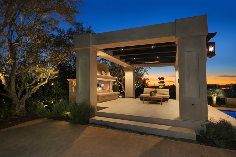 Cette photo montre une grande terrasse arrière tendance avec un foyer extérieur, du carrelage et un gazebo ou pavillon.