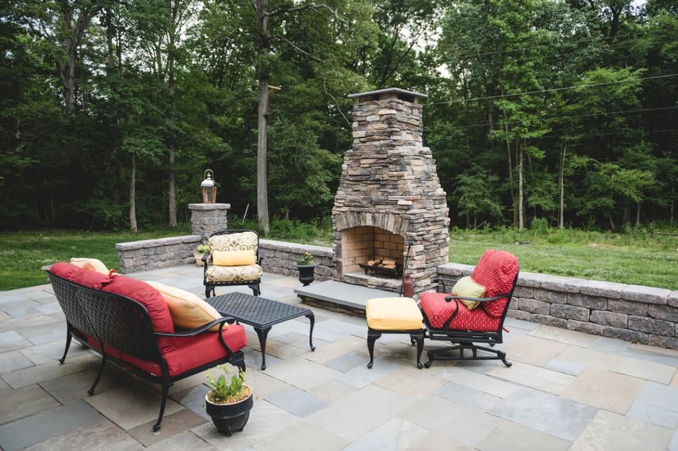 Immagine di un grande patio o portico tradizionale dietro casa con un focolare, pavimentazioni in pietra naturale e nessuna copertura