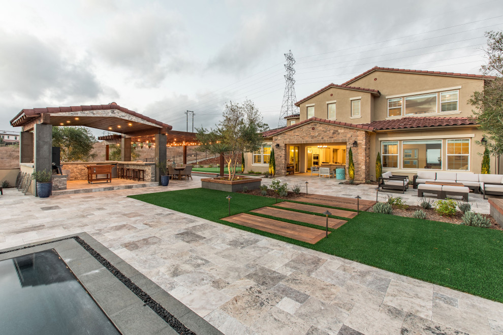 Foto di un grande patio o portico design dietro casa con pavimentazioni in pietra naturale e una pergola