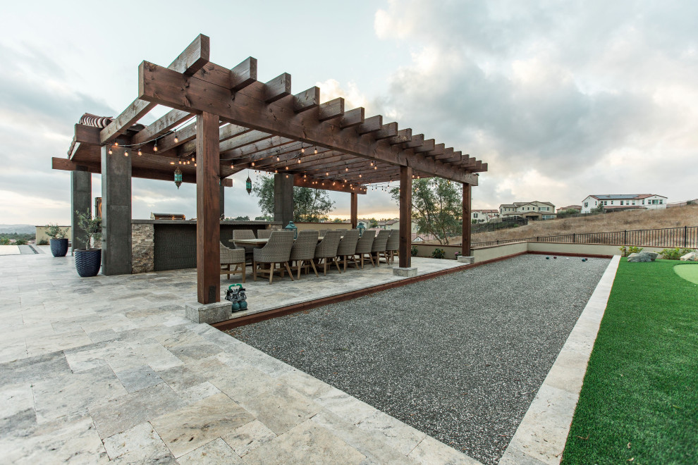 Foto di un grande patio o portico design dietro casa con pavimentazioni in pietra naturale e una pergola