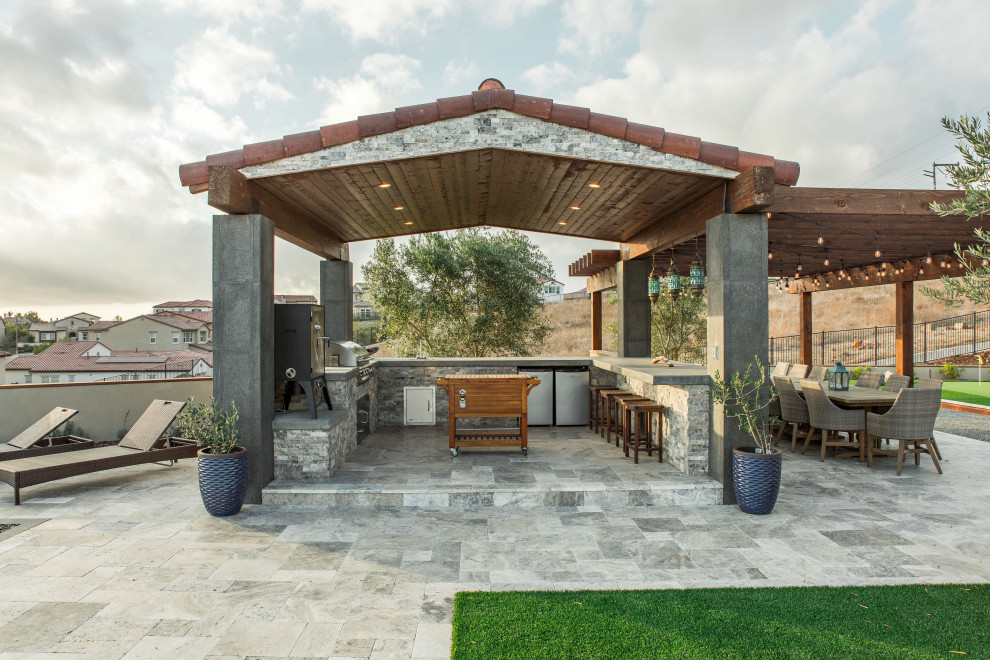 Esempio di un grande patio o portico design dietro casa con un focolare, pavimentazioni in pietra naturale e una pergola