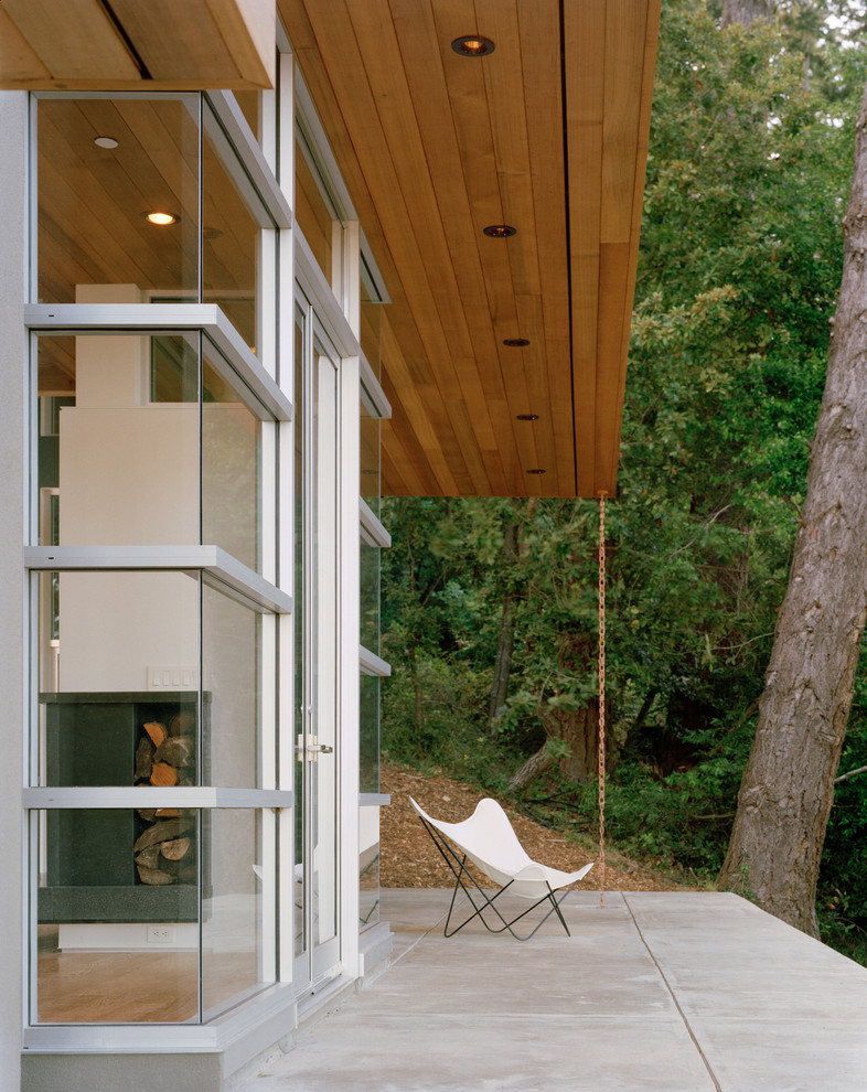На фото: двор среднего размера в стиле модернизм с покрытием из бетонных плит и навесом
