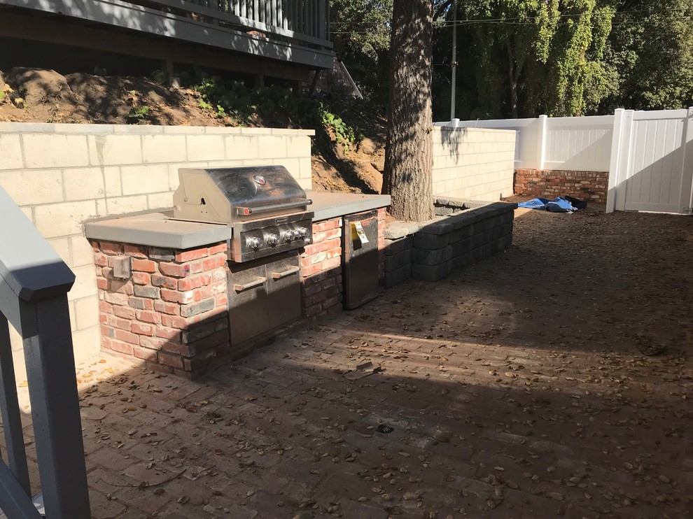 Großer, Unbedeckter Klassischer Patio neben dem Haus mit Outdoor-Küche und Pflastersteinen in Los Angeles