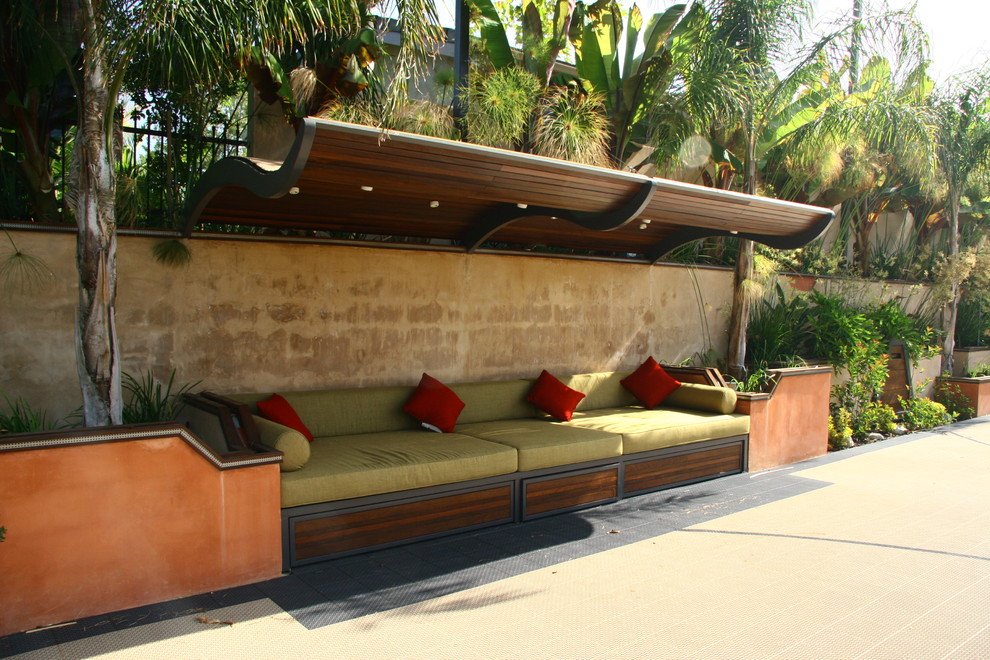 Diseño de patio actual grande en patio trasero con adoquines de hormigón y toldo