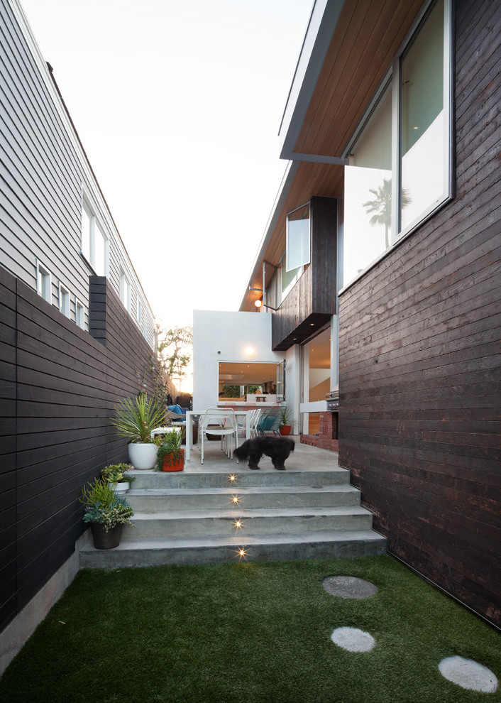 Idee per un patio o portico contemporaneo di medie dimensioni con lastre di cemento, nessuna copertura e scale