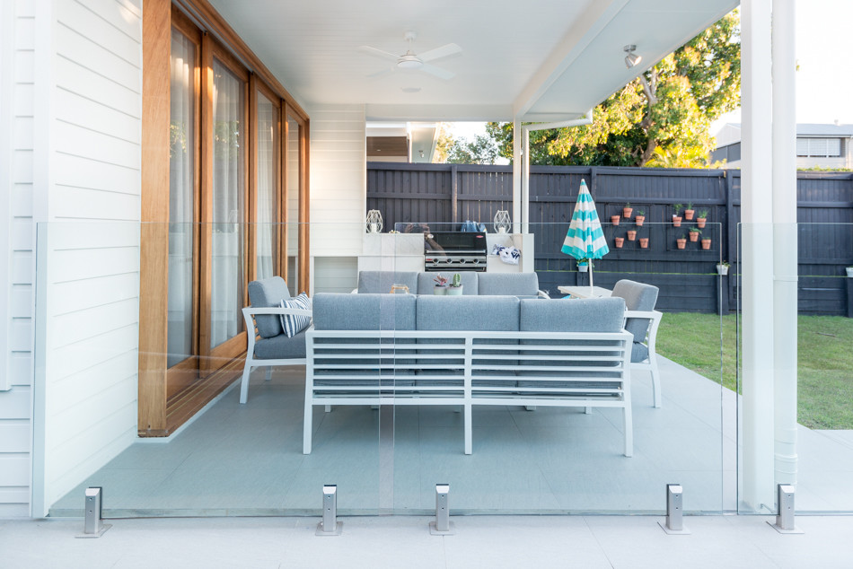 Imagen de patio escandinavo de tamaño medio en patio trasero con cocina exterior, adoquines de hormigón y toldo