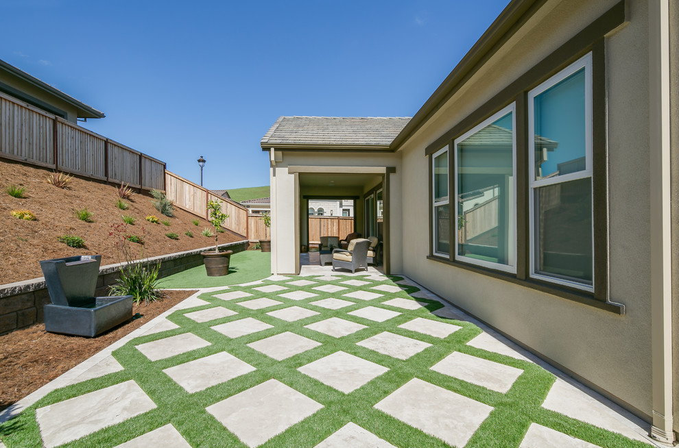 Foto di un patio o portico minimal di medie dimensioni e dietro casa con pavimentazioni in cemento e un tetto a sbalzo