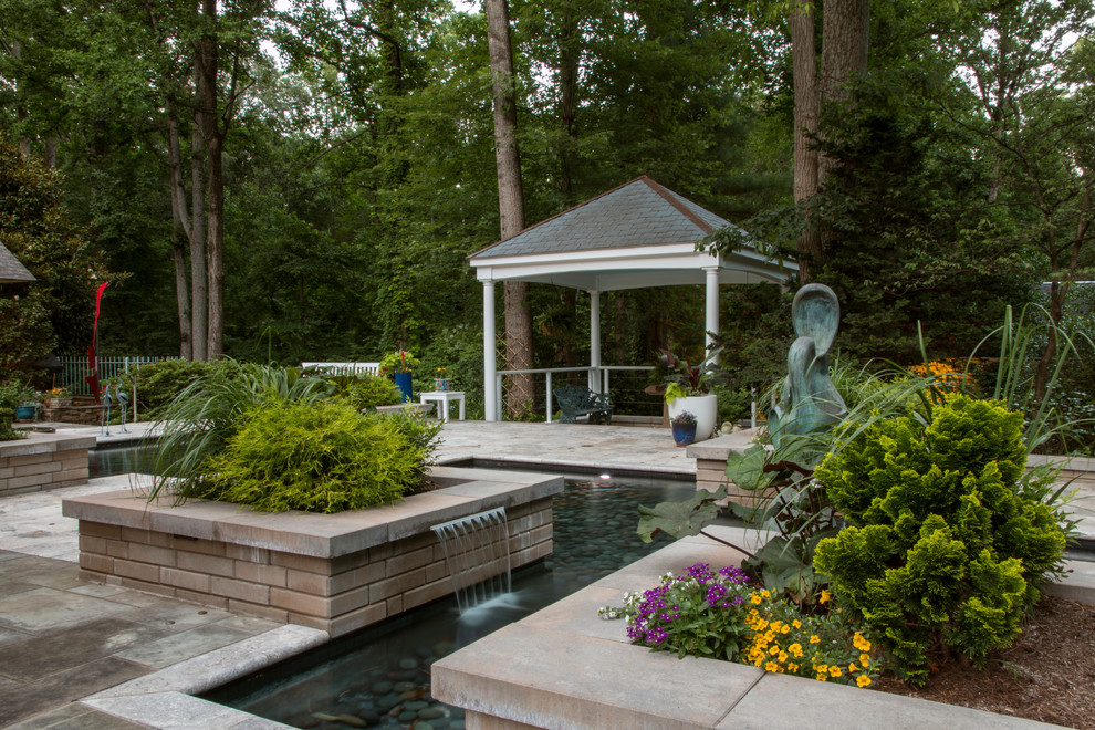 Modelo de patio contemporáneo de tamaño medio en patio trasero con jardín de macetas, adoquines de piedra natural y pérgola