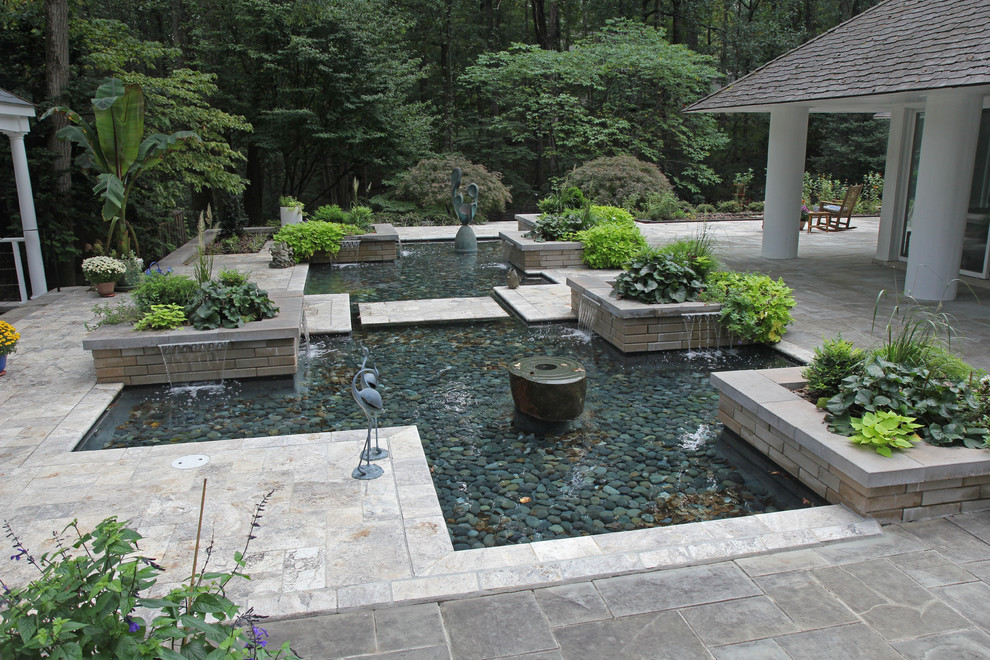 Foto de patio actual de tamaño medio en patio trasero con jardín de macetas, pérgola y adoquines de piedra natural