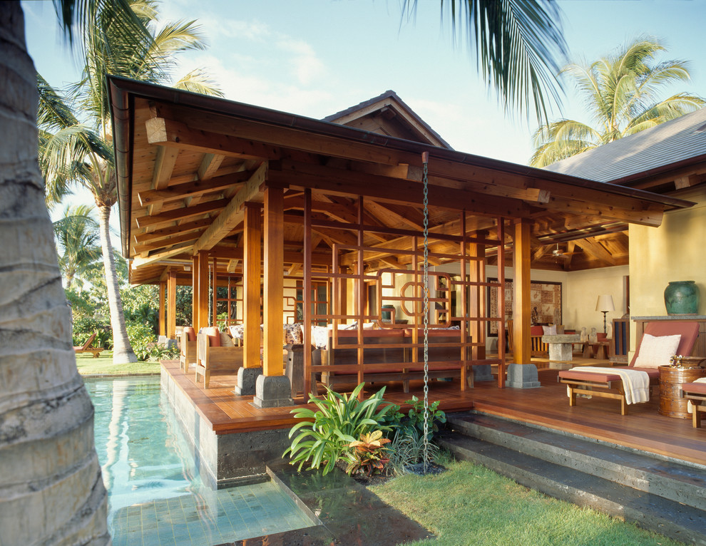 Immagine di un patio o portico tropicale con pedane e un tetto a sbalzo