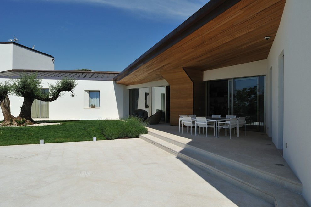 Idées déco pour une terrasse moderne avec une dalle de béton et une extension de toiture.