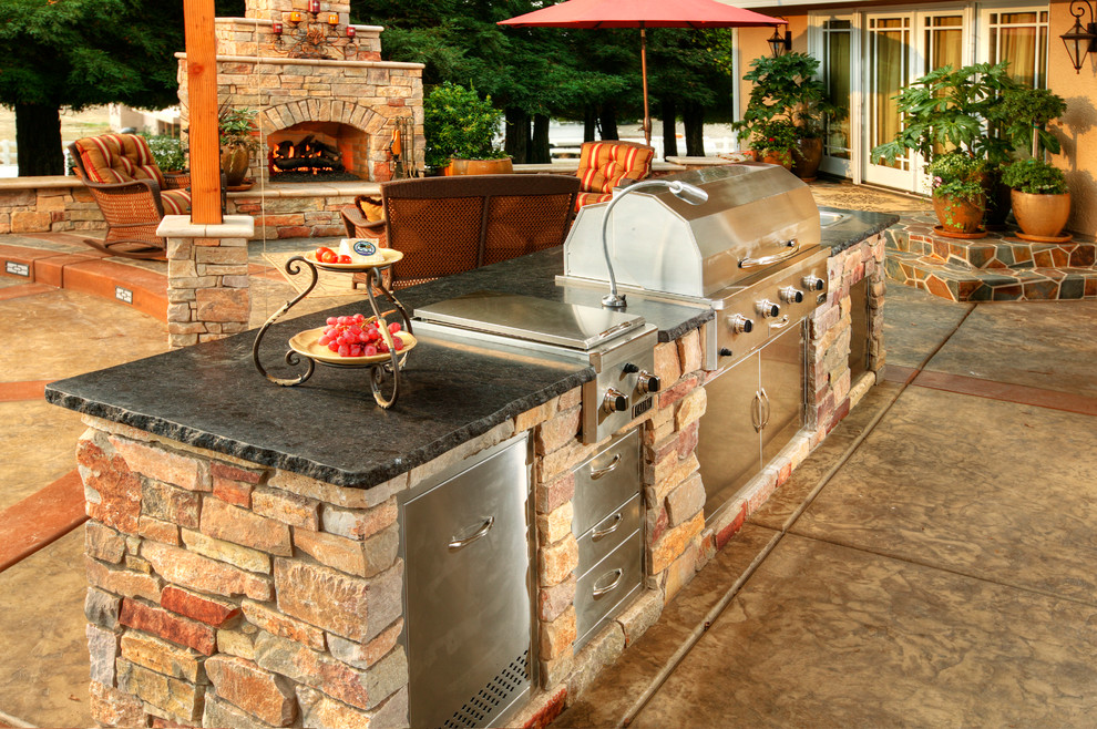 Inspiration for a large traditional back patio in Las Vegas with an awning, a fire feature and stamped concrete.