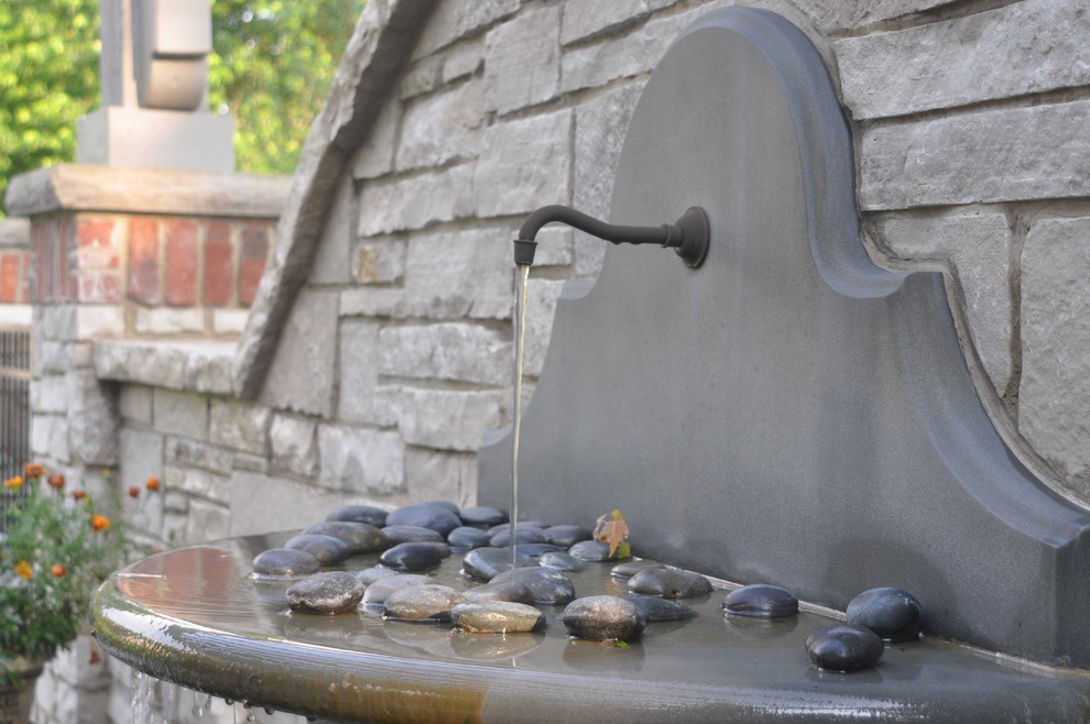 Пример оригинального дизайна: пергола во дворе частного дома на заднем дворе в классическом стиле с фонтаном и покрытием из каменной брусчатки