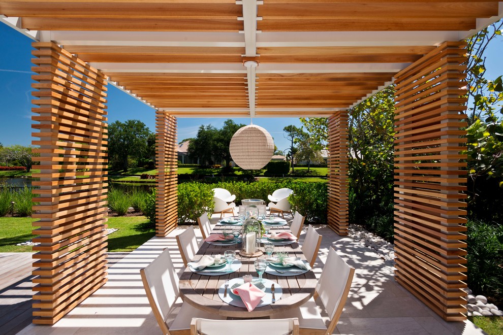 Inspiration for a coastal backyard concrete patio remodel in Miami with a pergola