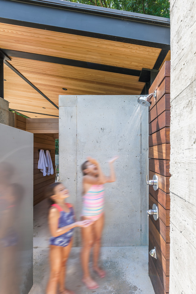 Foto de patio contemporáneo con losas de hormigón y ducha exterior