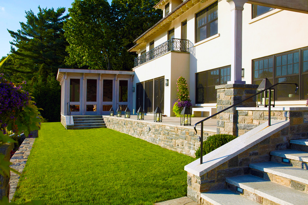 Immagine di un ampio patio o portico classico dietro casa con fontane, graniglia di granito e una pergola