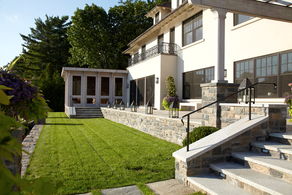 Exemple d'une terrasse chic avec une cour, des pavés en pierre naturelle et une pergola.