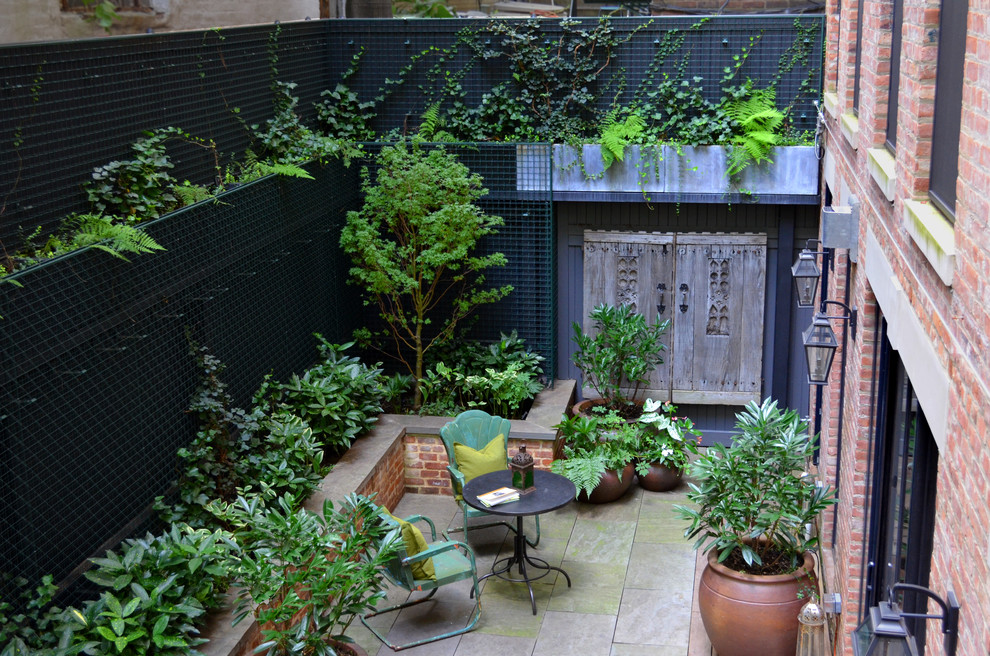 Transitional courtyard patio photo in New York