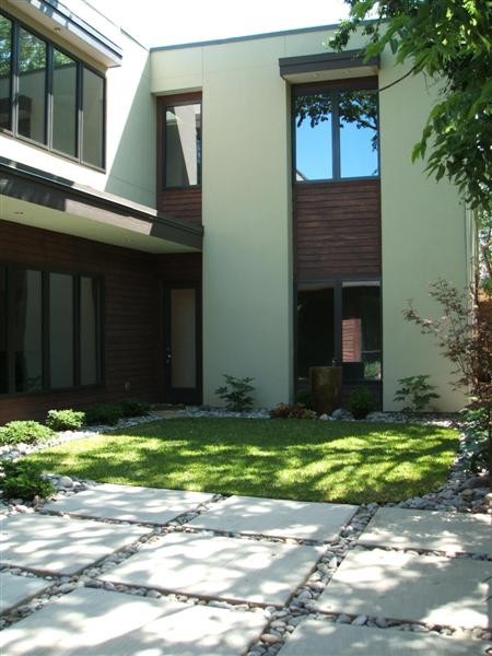 Aménagement d'une grande terrasse moderne avec une cour, des pavés en pierre naturelle et aucune couverture.
