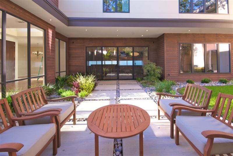 Patio - large modern courtyard stone patio idea in Dallas with no cover