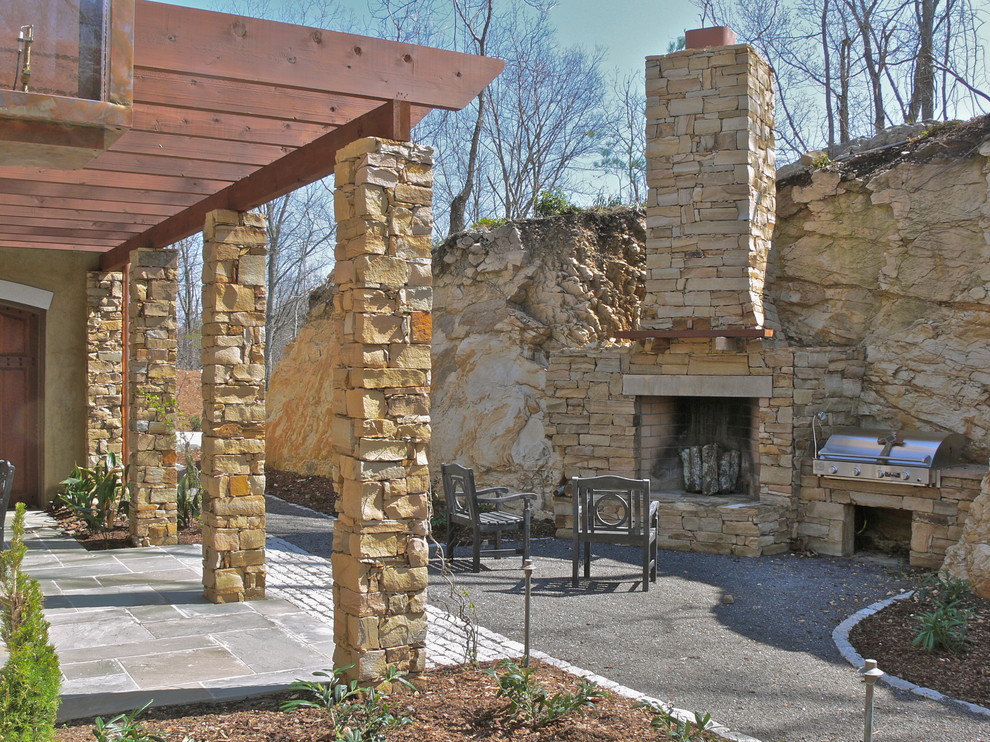 Immagine di un patio o portico contemporaneo con un focolare e una pergola