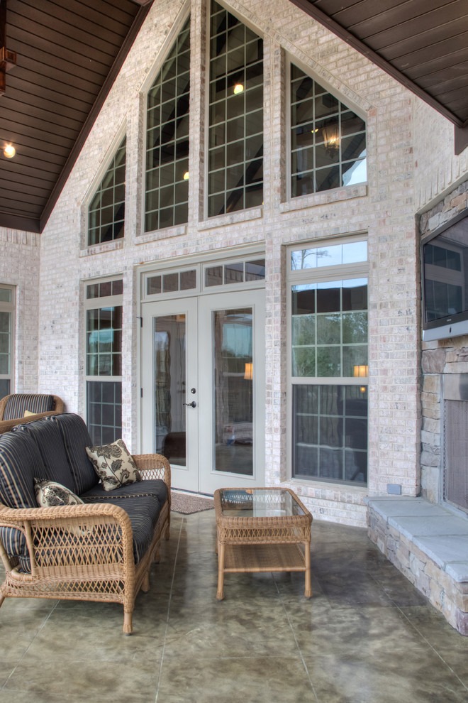 Überdachter Klassischer Patio hinter dem Haus mit Outdoor-Küche und Betonplatten in Sonstige