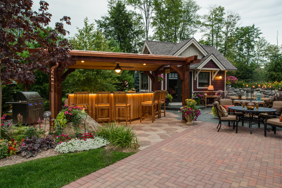 Medium sized traditional back patio in Other with brick paving, a pergola and a bar area.